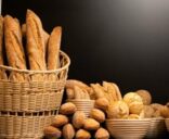 A variety of delicious breads displayed in a basket and bowls, perfect for bakery themes.